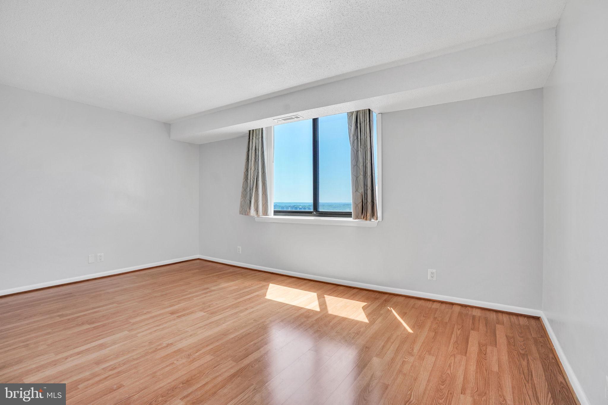 5501 Seminary Road, Unit 1908S Falls Church, VA 22041 - Photo 27 of 43 a view of an empty room with wooden floor and a window