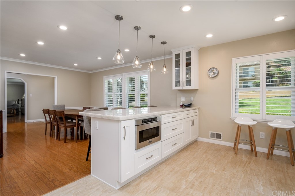 12430 Beverly Drive Whittier, CA 90601 - Photo 6 of 31 a large white kitchen with lots of counter space and dining table