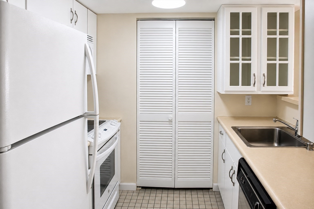20 Webster Street, Unit 211 Brookline, MA 02446 - Photo 4 of 8 a kitchen with a white cabinets and white stove