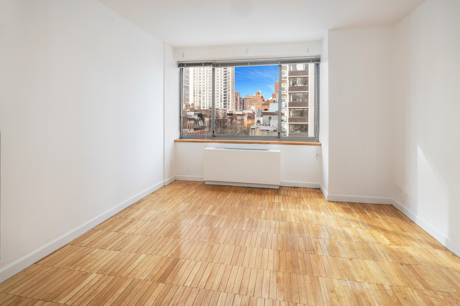 401 East 84th Street, Unit 5D Manhattan, NY 10028 - Photo 5 of 7 an empty room with wooden floor and windows