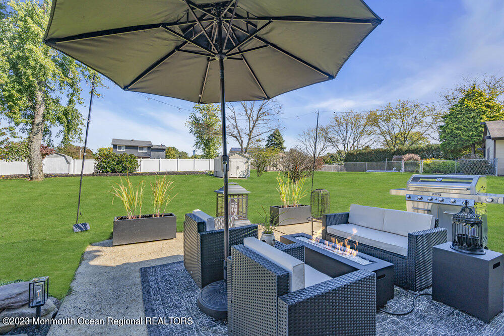 8 Hillside Road Manalapan, NJ 07726 - Photo 54 of 59 a view of a patio with couches under an umbrella