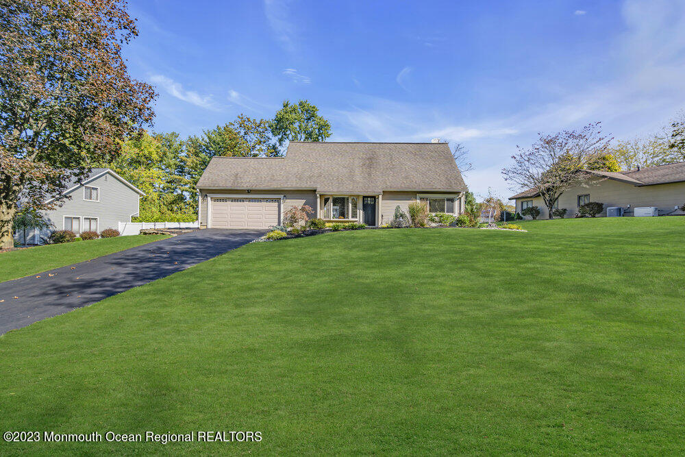 8 Hillside Road Manalapan, NJ 07726 - Photo 6 of 59 a front view of a house with a garden