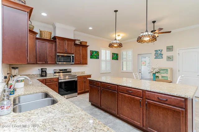 a kitchen with stainless steel appliances granite countertop wooden cabinets a stove top oven a sink and dishwasher