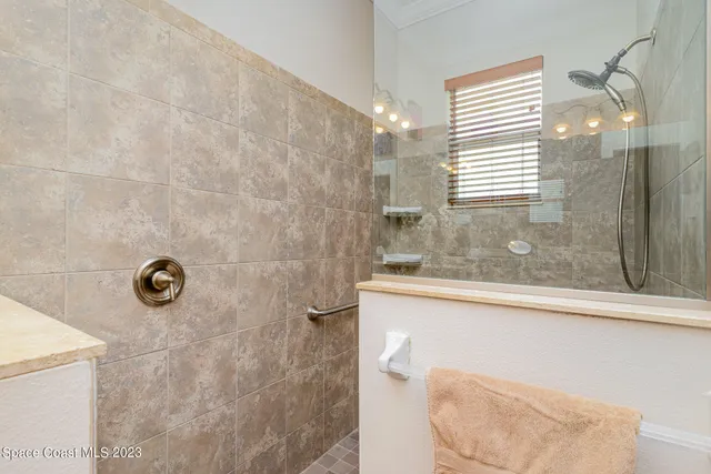 a bathroom with a granite countertop sink a window and shower