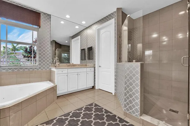 a bathroom with a double vanity sink a mirror and a bathtub