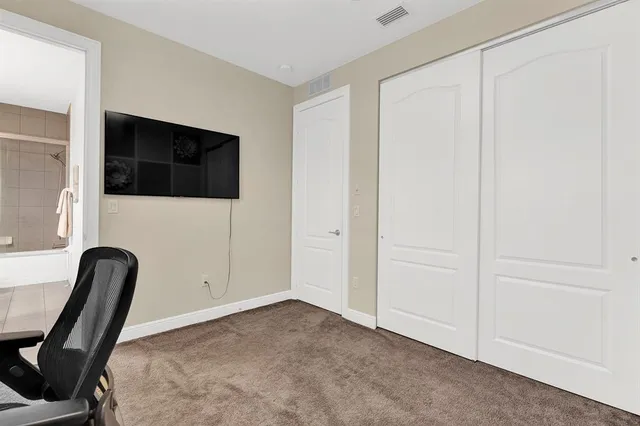 a view of a workspace with furniture and a window