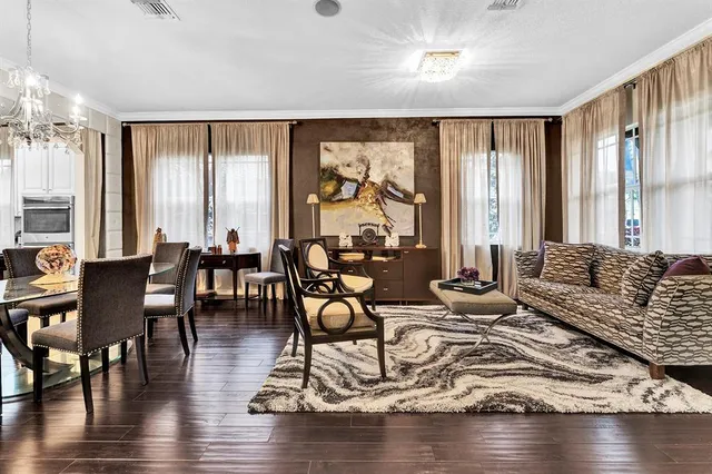 a living room with furniture large window and wooden floor