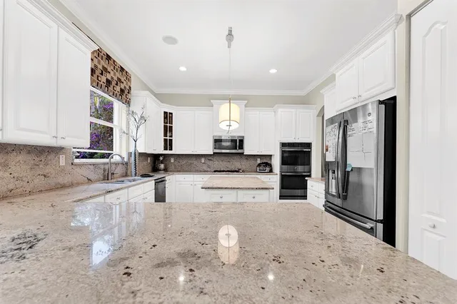 a kitchen with stainless steel appliances kitchen island granite countertop a refrigerator and a stove top oven