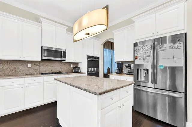 a kitchen with stainless steel appliances granite countertop a refrigerator a stove top oven a sink and dishwasher