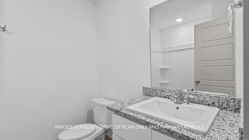 7331 9th Street Lubbock, TX 79416 - Photo 12 of 13 a bathroom with a granite countertop sink and a toilet