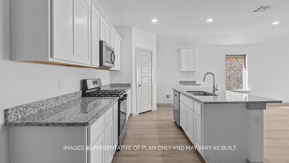 7331 9th Street Lubbock, TX 79416 - Photo 3 of 13 a kitchen with stainless steel appliances granite countertop a stove and a sink