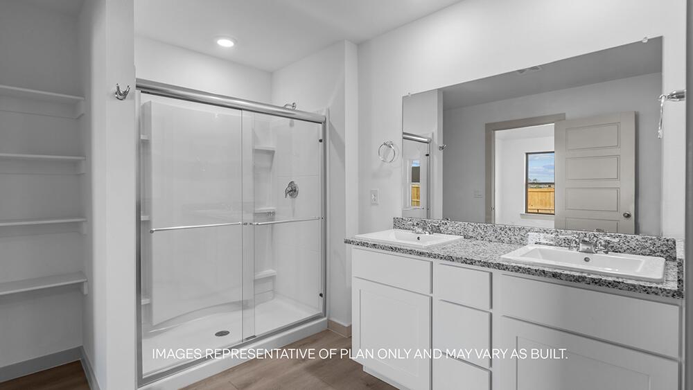 7331 9th Street Lubbock, TX 79416 - Photo 9 of 13 a bathroom with a granite countertop sink mirror and shower