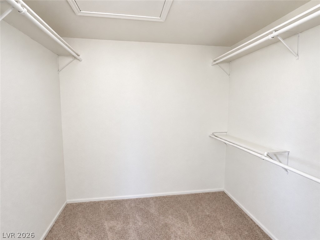43 Bayridge Road Henderson, NV 89074 - Photo 38 of 47 Ample hanging rods and shelving optimize storage within this carpeted walk-in closet.