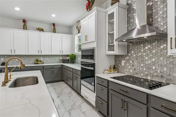 a large white kitchen with lots of counter space and appliances