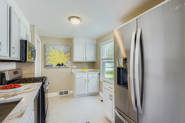 a kitchen with a refrigerator and a stove top oven