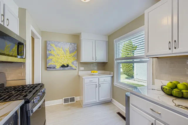 a kitchen with a sink a stove cabinets and a window