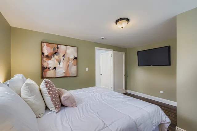 a bedroom with a bed and a painting on the wall