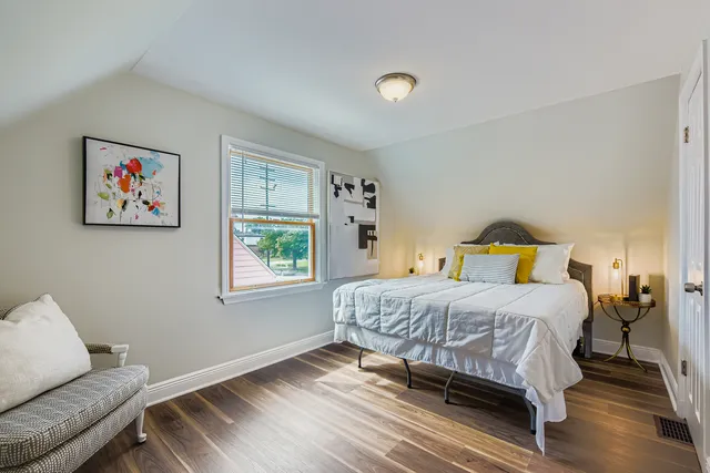 a bedroom with a bed and wooden floor