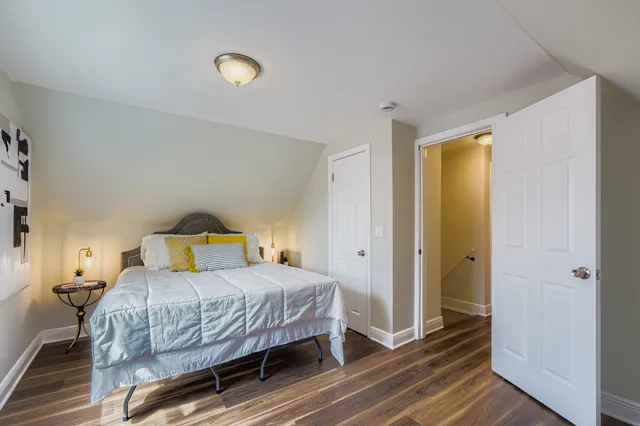 a bedroom with a bed and wooden floor