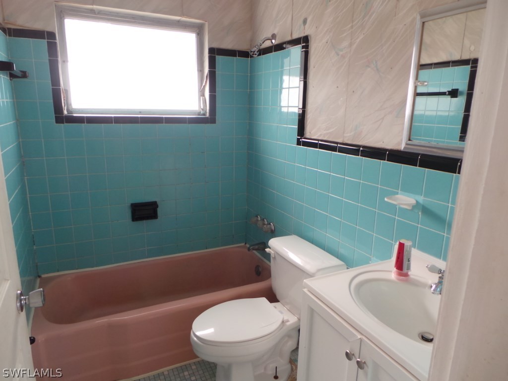 18596 Evergreen Road Fort Myers, FL 33967 - Photo 4 of 12 a bathroom with a toilet sink and mirror