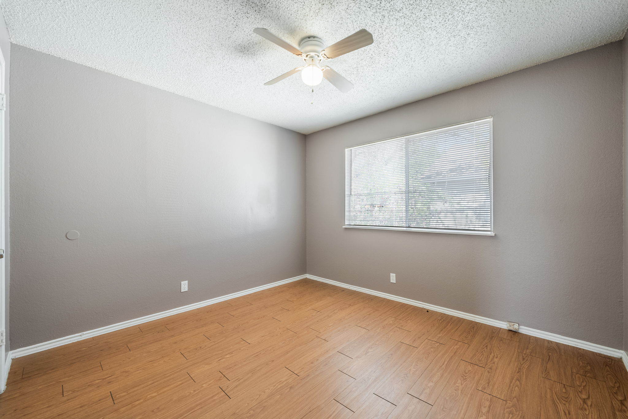 5807 Spring Meadow Road, Unit B Austin, TX 78744 - Photo 24 of 31 Well-lit living area with durable wood flooring and an overhead ceiling fan for comfort.