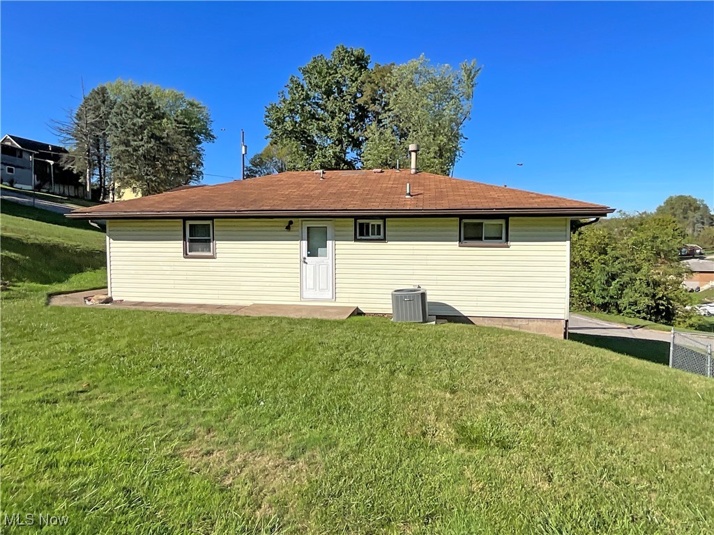 106 Ridgeway Avenue Weirton, WV 26062 - Photo 17 of 19 Rear view of property featuring central AC unit and a lawn