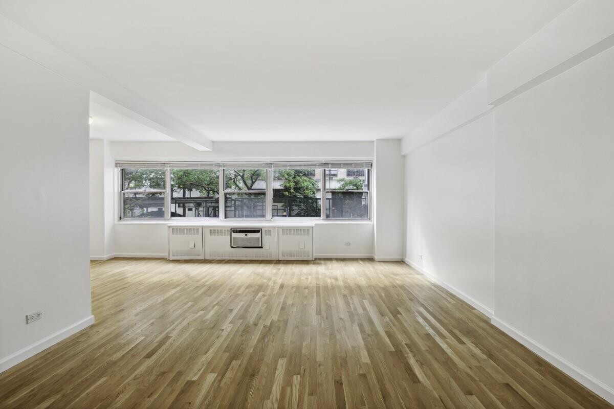 333 East 46th Street, Unit 2C Manhattan, NY 10017 - Photo 3 of 5 wooden floor in an empty room with a window