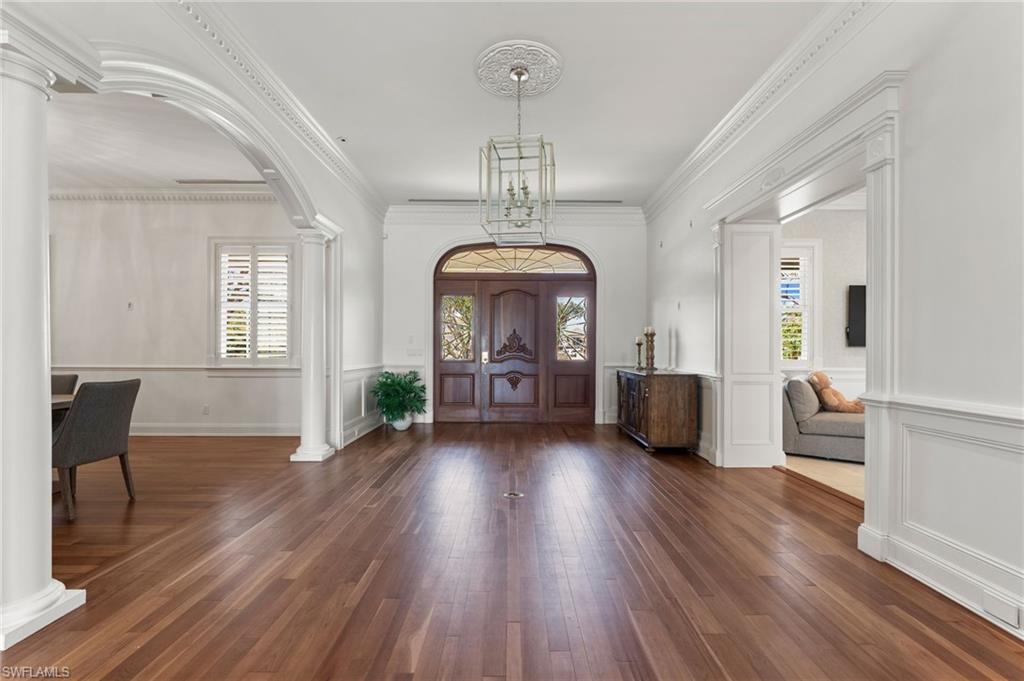 2325 Lantern Lane Naples, FL 34102 - Photo 11 of 50 Foyer entrance with decorative columns, arched walkways, wood finished floors, and a healthy amount of sunlight