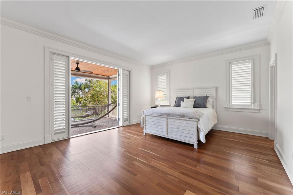 2325 Lantern Lane Naples, FL 34102 - Photo 33 of 50 Bedroom with visible vents, baseboards, ornamental molding, wood finished floors, and access to outside