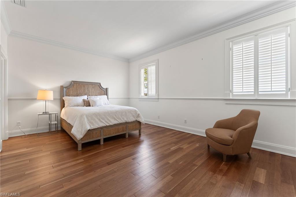 2325 Lantern Lane Naples, FL 34102 - Photo 34 of 50 Bedroom featuring wood finished floors, baseboards, ornamental molding, and visible vents