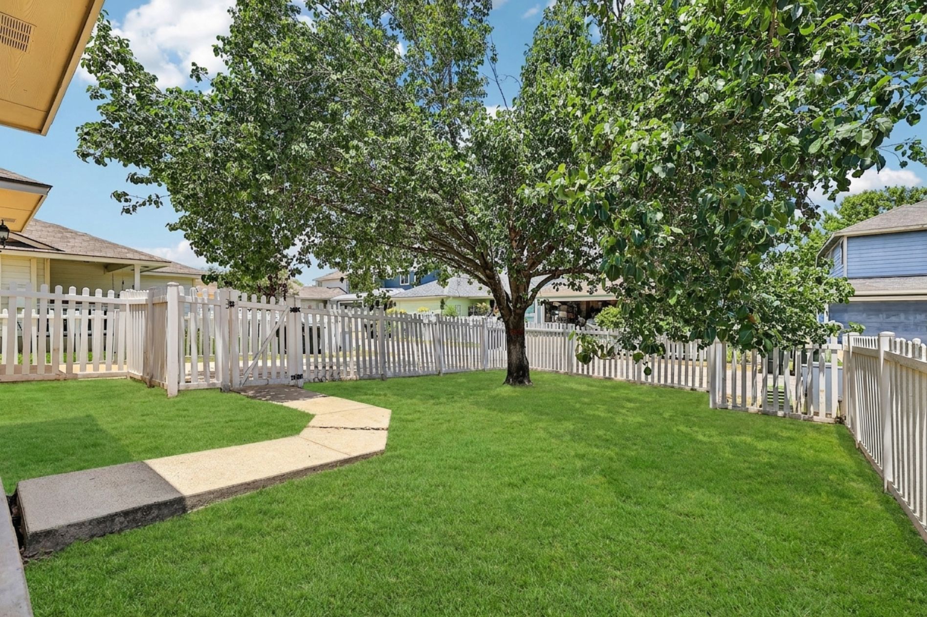 616 Scheel Road Kyle, TX 78640 - Photo 34 of 39 A neatly fenced private yard with a mature tree offers a serene outdoor space.
