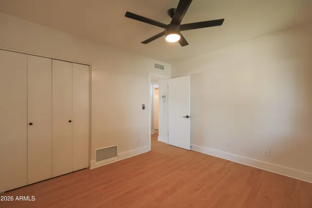an empty room with closet and fan