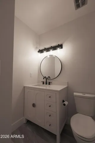 a bathroom with a toilet a sink and mirror