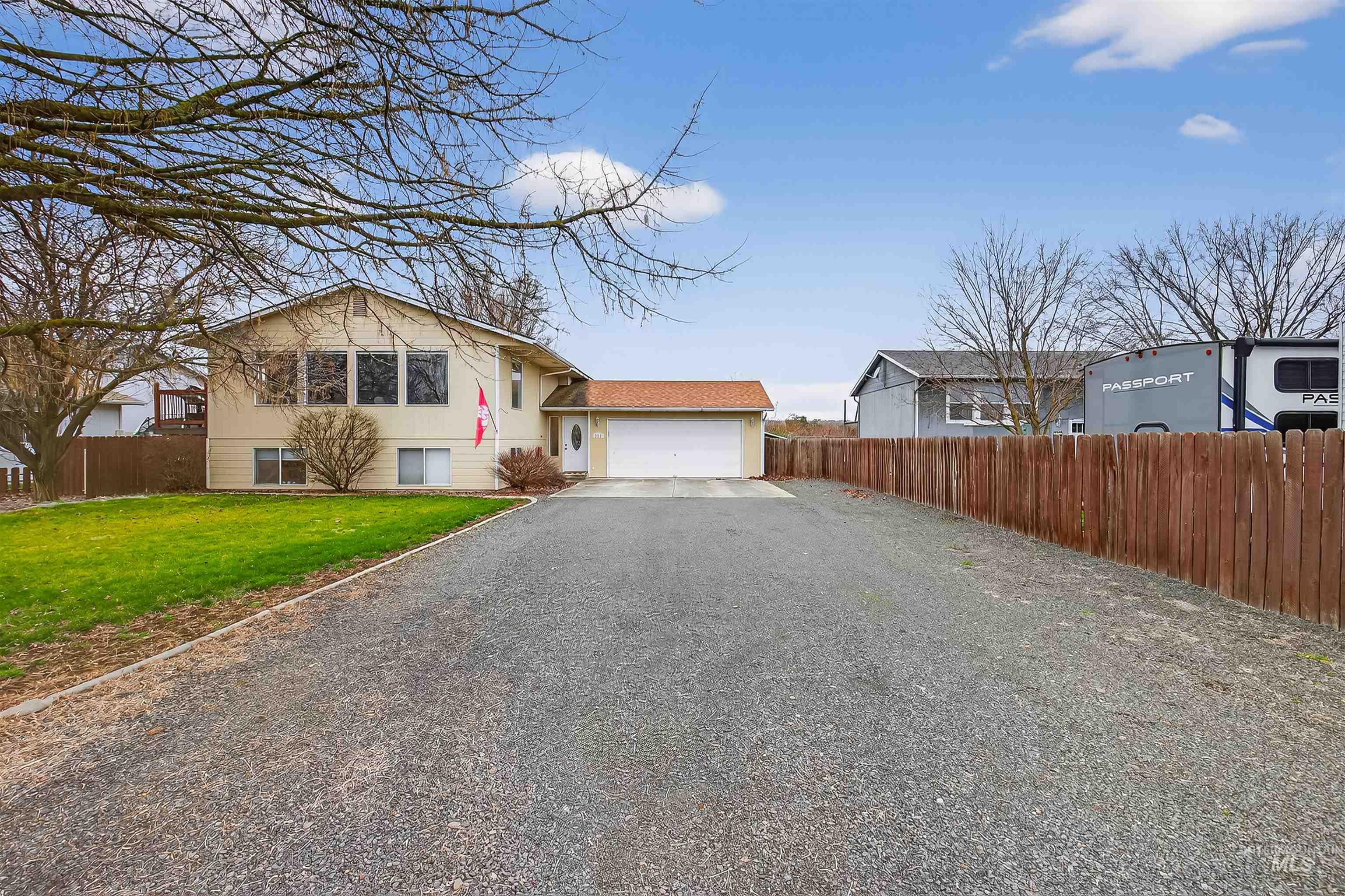View of front facade featuring driveway and an attached garage