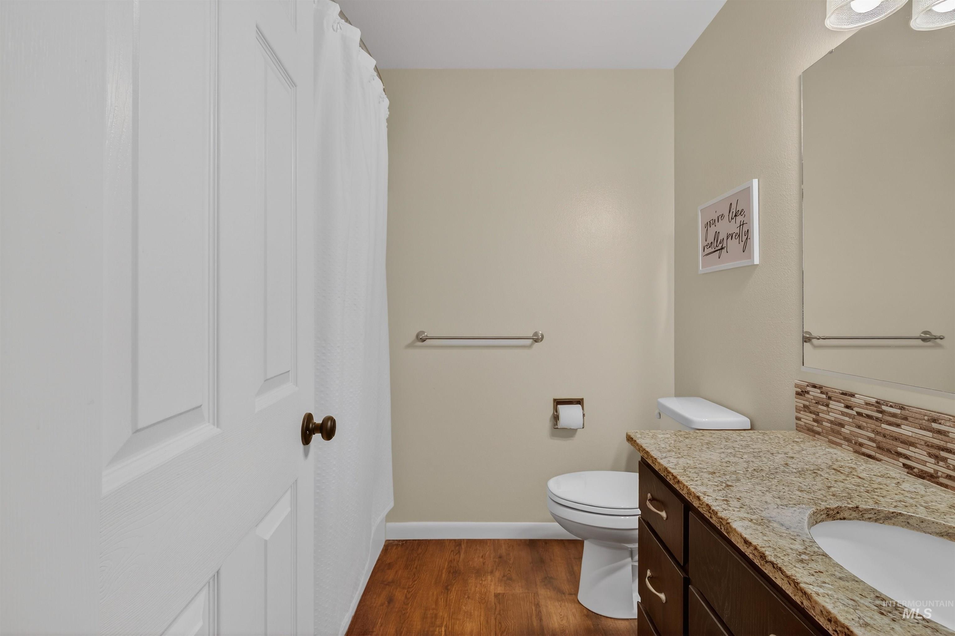 2814 22nd Street Clarkston, WA 99403 - Photo 11 of 33 Full bathroom featuring backsplash, vanity, a shower with curtain, and dark wood-type flooring