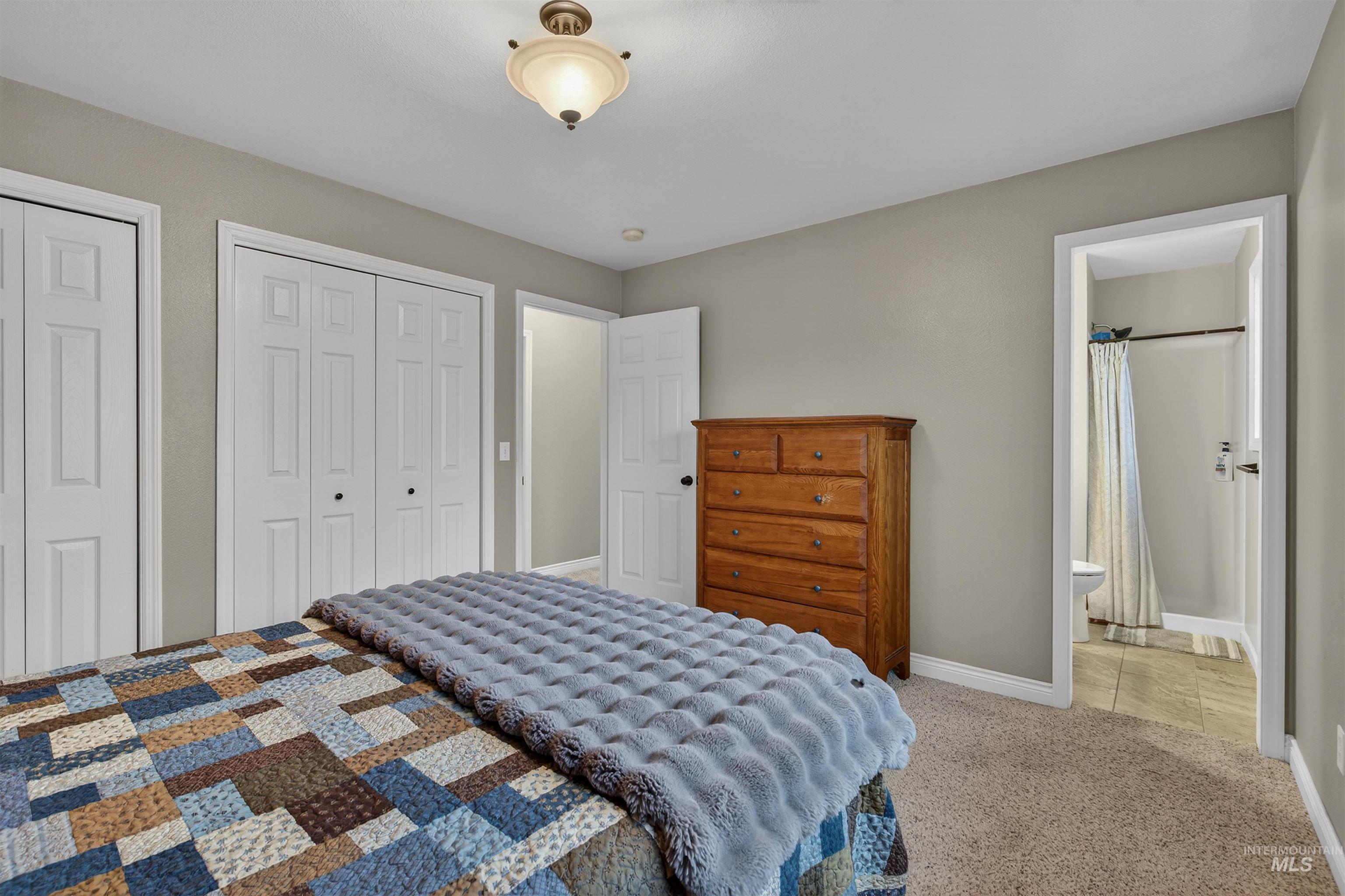 2814 22nd Street Clarkston, WA 99403 - Photo 13 of 33 Bedroom with multiple closets, light carpet, and ensuite bath