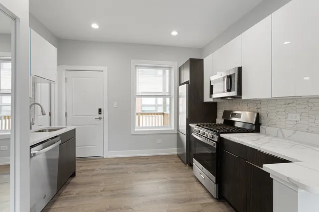 a kitchen with granite countertop a stove top oven sink and cabinets