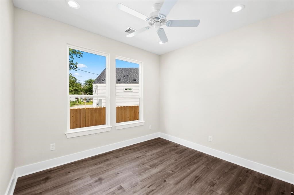 6832 Morrow Street, Unit A Houston, TX 77091 - Photo 5 of 16 an empty room with wooden floor and windows