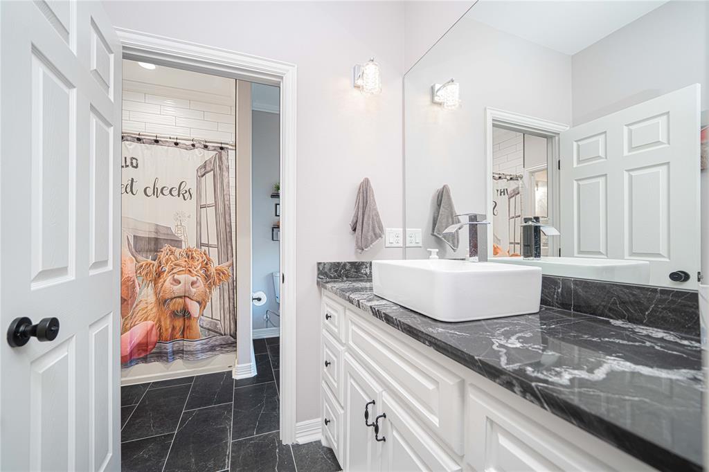 145 County Road Pittsburg, TX 75686 - Photo 28 of 39 a bathroom with a granite countertop sink and a mirror
