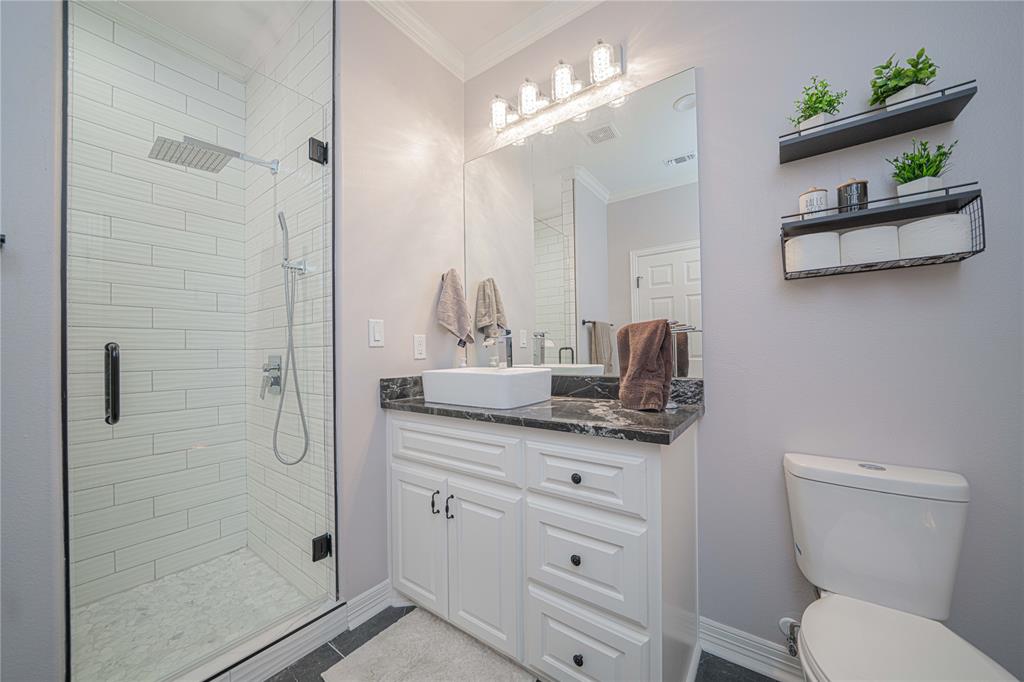 145 County Road Pittsburg, TX 75686 - Photo 32 of 39 a bathroom with a granite countertop sink a toilet a mirror and shower