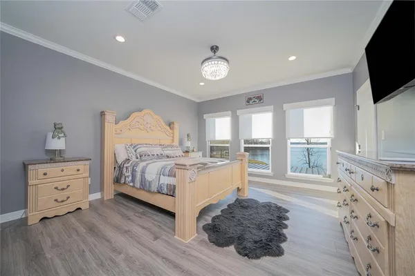 a spacious bedroom with a bed and a flat screen tv