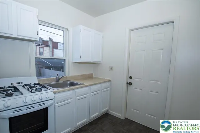 a kitchen with cabinets appliances and a window