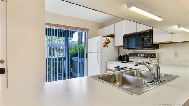a kitchen with a sink a refrigerator and a microwave