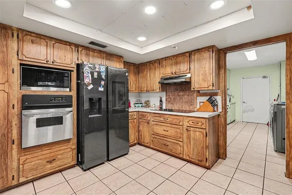 a kitchen with stainless steel appliances granite countertop a refrigerator and a stove top oven