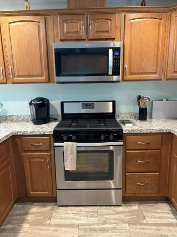 a kitchen with granite countertop cabinets stainless steel appliances and a sink