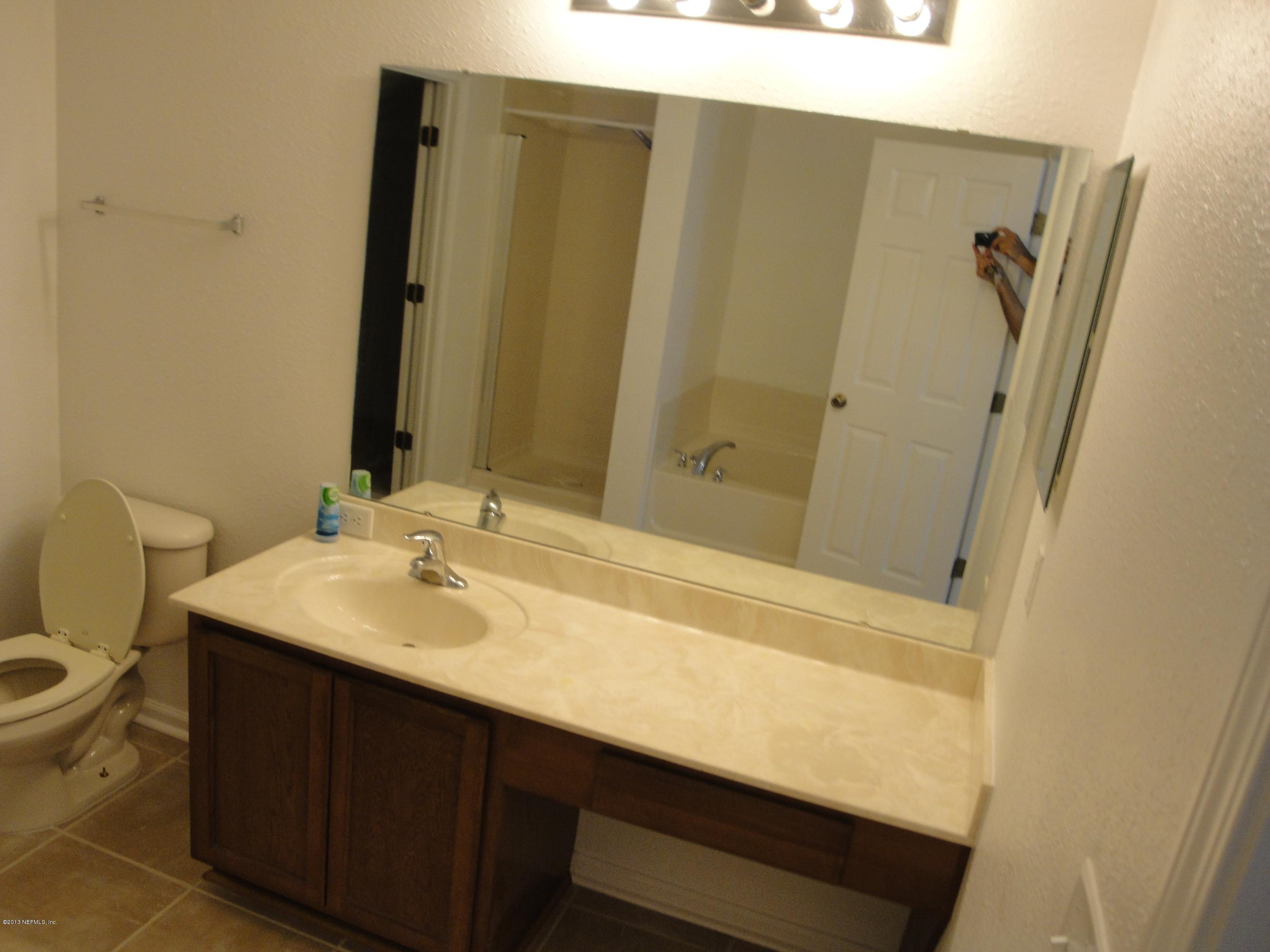 7266 South Rampart Ridge Jacksonville, FL 32244 - Photo 19 of 22 a bathroom with a sink a toilet and a mirror