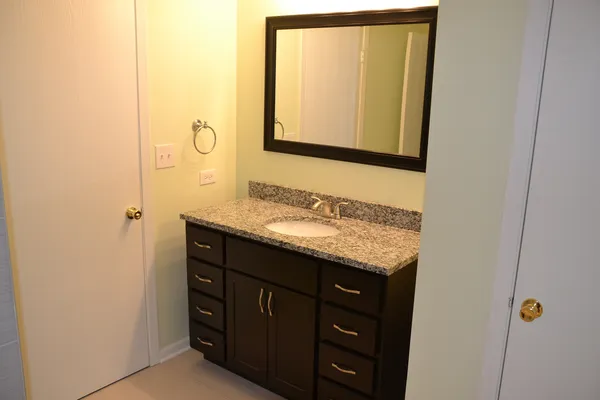 a bathroom with a granite countertop sink and a mirror