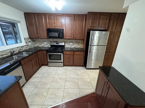 a kitchen with stainless steel appliances a stove a refrigerator and a sink
