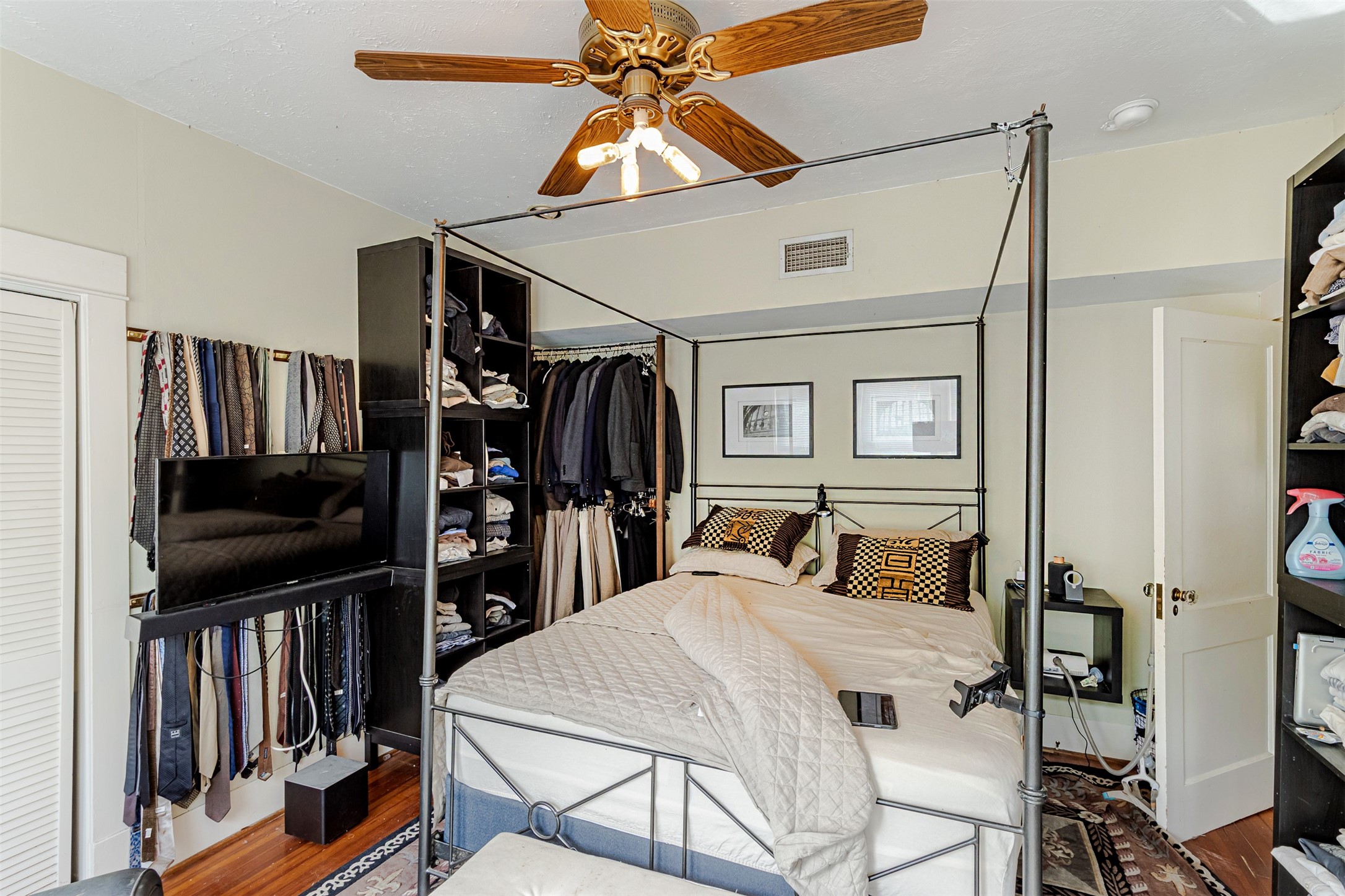 528 Hawthorne Street Houston, TX 77006 - Photo 7 of 34 a bedroom with a bed a flat screen tv and a bookshelf