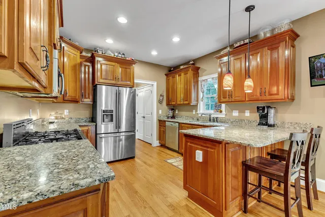a kitchen with granite countertop stainless steel appliances a sink window and cabinets